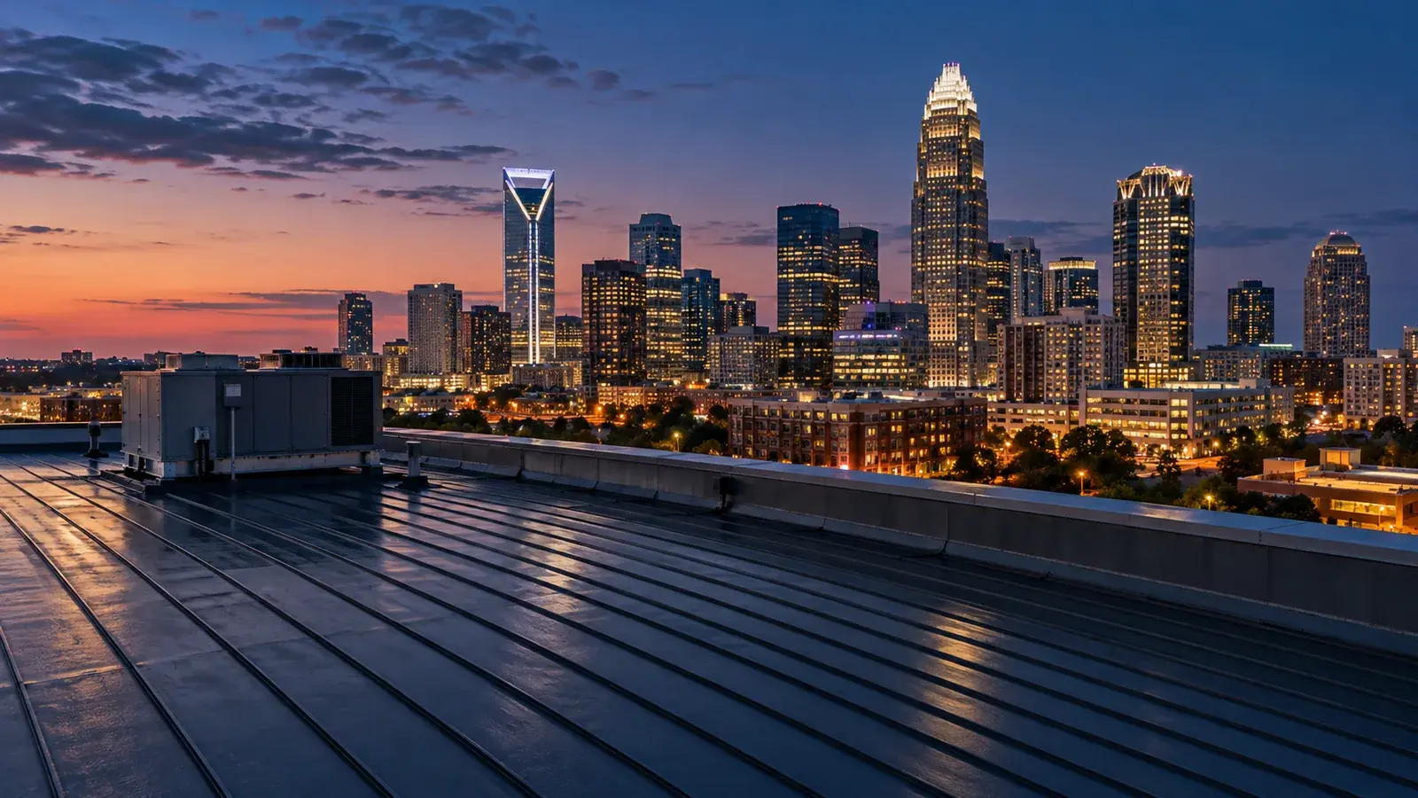 Illustrative Charlotte skyline at blue hour viewed across a commercial rooftop.
